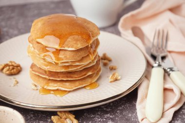 Gri arka planda fındık ve akçaağaç pekmezli lezzetli krepler.