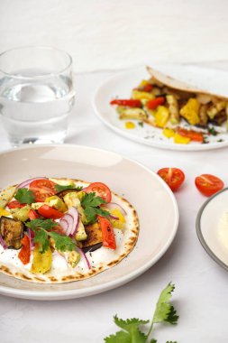 Beyaz arka planda ızgara sebzeli lezzetli pita ekmeği.