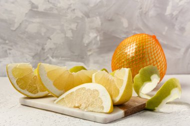 Lezzetli pomelo meyvesi ağda, kabuğu soyup beyaz masaya koyun.