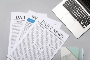 Beyaz arka planda dizüstü bilgisayarı, defteri ve kalemi olan gazeteler