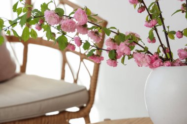 Odada çiçek açan dalları olan bir vazo. Yakın çekim.