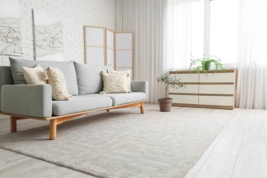 Rahat kanepesi, katlanır perdesi, çekmecesi ve halısı olan şık bir oturma odası.