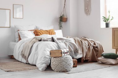 Büyük, rahat bir yatak ve bavul yatak odasında.