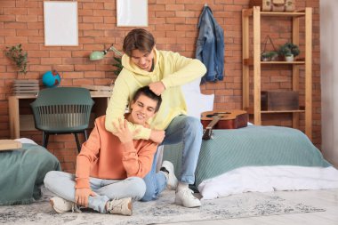 Erkek öğrenciler yurt odasında sarılıyorlar.