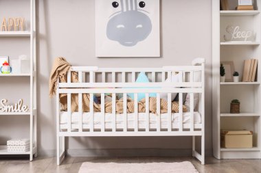 Beşik ve hayvan resimleri olan hafif çocukların yatak odasının içinde.