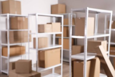 Raf birimleri ve karton kutularla dolu bulanık depo görüntüsü