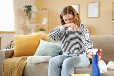 Daireyi temizlerken alerjisi olan genç bir kadın.