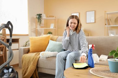 Temizlik yaparken kendini kaşıyan genç bir kadın. Alerji konsepti
