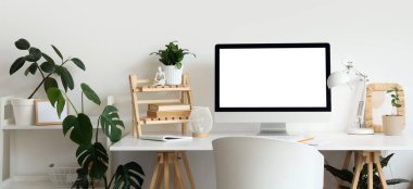 Modern çalışma alanı, bilgisayar monitörü ve ev bitkilerine sahip ışık ofisinin içi