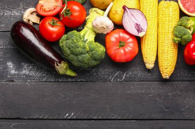 Koyu ahşap arka planda taze taze sebzeler.