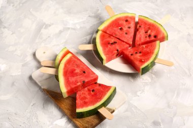 Arkaplanda tatlı karpuz çubukları olan tabak ve yemek.