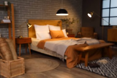 Gece yatak odasının bulanık manzarası, parlayan lambalar ve ahşap banklar.