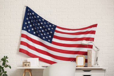 Rahat çalışma alanının üzerinde Amerikan bayrağı asılı modern oturma odasının içi
