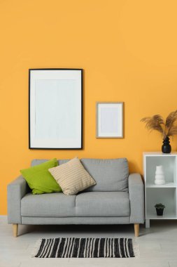 Oturma odasının iç tarafında rahat bir kanepe ve raf var.