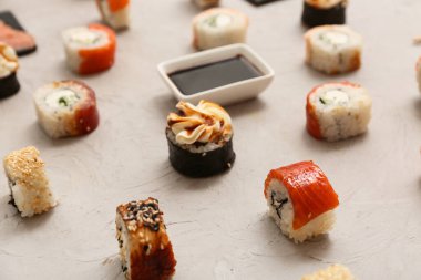 Gri grunge arka planda soya soslu lezzetli suşi ruloları, yakın plan.