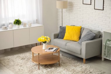 Oturma odasının iç tarafında yastıkları ve kahve masası olan rahat bir kanepe.