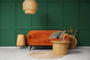 Kırmızı kanepesi, masası ve lambaları olan şık bir oturma odası.