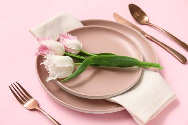 Pembe arka planda güzel laleleri olan şık masası.