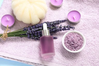 Havlu, deniz tuzu, lavanta çiçekleri ve eflatun arkaplanlı banyo süngeri ile harika bir kompozisyon, yakın plan.