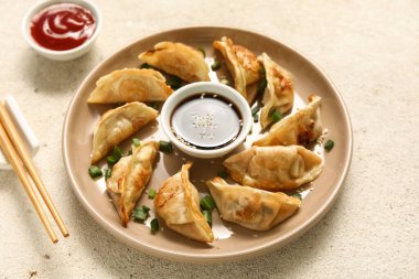 Kızarmış Japon gyoza tabağı ve beyaz arka planda soya sosu.