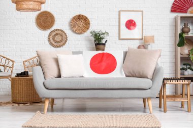 Oturma odasının içi. Kanepe üzerinde Japon bayrağı ve resim var.