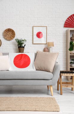 Oturma odasının içi. Kanepe üzerinde Japon bayrağı ve resim var.