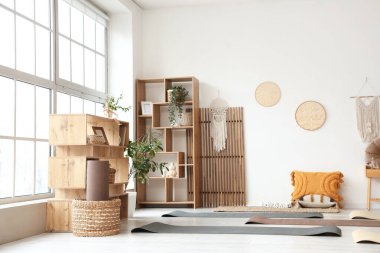 Paspaslı, bitkili ve raf üniteli hafif yoga stüdyosunun içi.