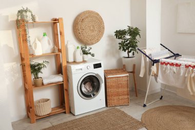 Çamaşır makinesi, raf ünitesi ve kurutuculu çamaşır odasının içi.