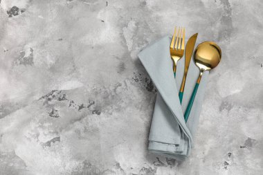 Gri grunge arka planında çatal bıçak takımı olan peçete