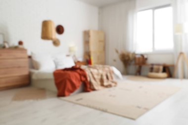 Modern yatak odasının bulanık manzarası, rahat yatak odası ve beyaz tuğla duvarın yanında birçok dekor elemanı.