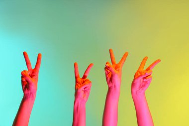 Renkli arka planda zafer jesti gösteren tonlanmış kadın elleri