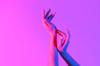 Pembe arka planda tonlanmış kadın elleri