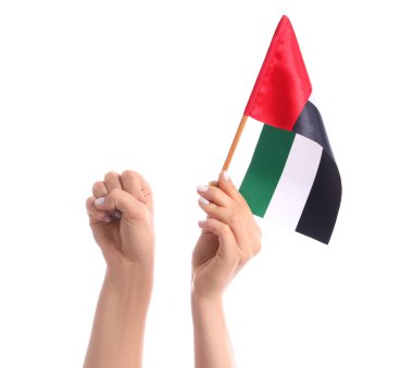 Yumruğunu sıkan kadın elleri ve beyaz arka planda BAE bayrağı