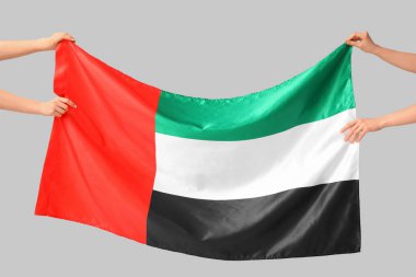 Hafif arkaplanda BAE bayrağı olan kadın eller