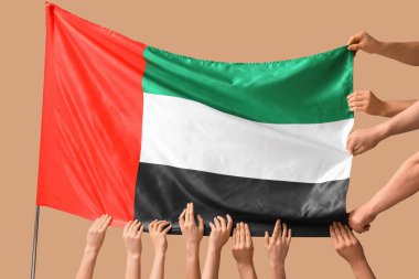 Bej arkaplanda BAE bayrağı olan birçok el