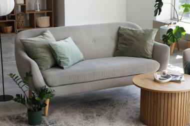 Oturma odasında sehpası ve çiçekleri olan rahat bir kanepe.