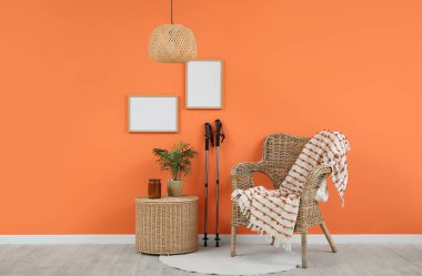 Odanın içinde İskandinav yürüyüş direkleri, koltuk ve sepeti var.