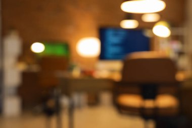 Programcının ofisini akşam masaları ve parlayan lambalarla bulanık görmek