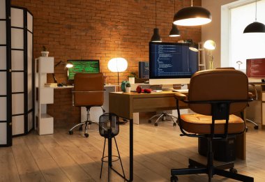 Akşamları masaları ve parlak lambaları olan programcı ofisinin içinde.