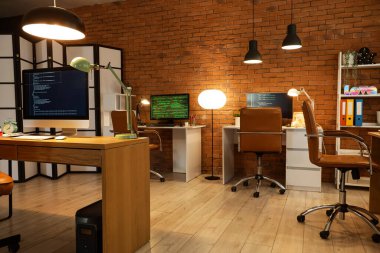 Akşamları masaları ve parlak lambaları olan programcı ofisinin içinde.