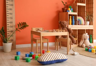 Masası, stadyumu ve dağınık oyuncakları olan dağınık çocuk odasının içi.