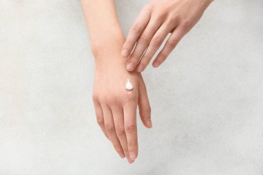 Beyaz grunge arka planında krema lekesi olan kadın elleri