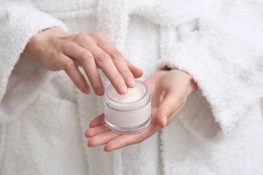 Bir kavanoz kremalı genç kadın, yakın plan.