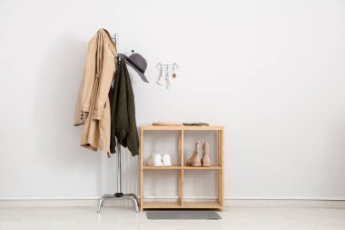 Elbise askılığı, ayakkabı rafı ve anahtar tutacağı beyaz duvarlı şık bir salon.