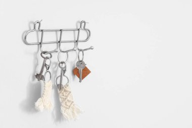 Anahtarlar beyaz duvarda asılı, yakın plan.