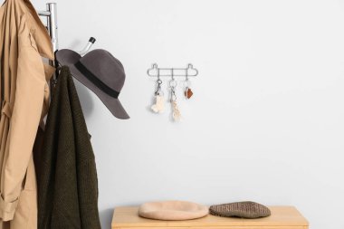 Giysi rafı, raf ve anahtar tutacağı beyaz duvarlı şık bir salon.