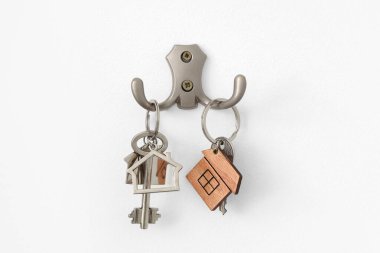 Anahtarlar beyaz duvarda asılı, yakın plan.