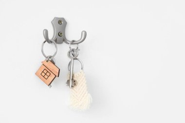 Anahtarlar beyaz duvarda asılı, yakın plan.