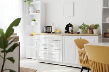 Mutfağın içinde tezgah, kahve makinesi ve raf ünitesi var.