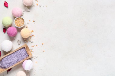 Beyaz arka planda deniz tuzu ve taç yapraklı banyo bombaları.